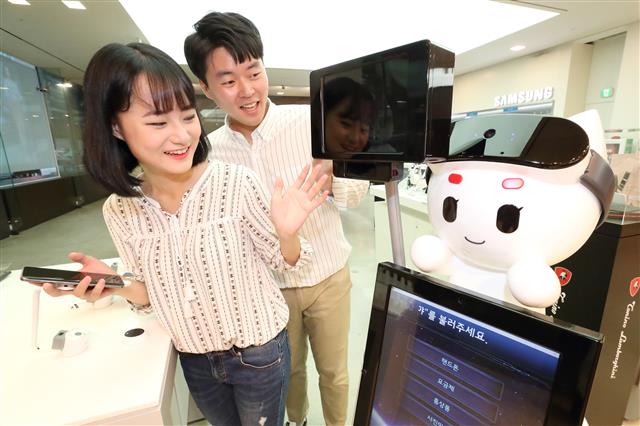 30일 서울 강남구 KT 지니 스토어에서 모델들이 인공지능 대화형 로봇인 ‘지니봇’을 소개하고 있다. KT 제공