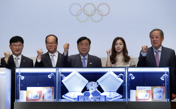 1일 오전 충정로 풍산빌딩에서 열린 2018 평창동계올림픽 기념은행권 및 기념주화(2차분) 실물 공개 발표회에서 평창동계올림픽 이희범 조직위원장(왼쪽 세번째부터)과 김연아 홍보대사 등 주요 인사들이 포즈를 취하고 있다. 이번에 발표되는 기념지폐와 기념주화는 9월 11~29일까지 11개의 지정 금융기관 전국지점과 판매대행사인 풍산화동양행을 통해 선착순 예약접수를 진행하고, 12월 11~15일까지 닷새 동안 교부할 예정이다. 연합뉴스