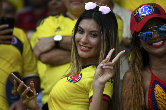 5일(현지시간) 콜롬비아 바랑키야에서 열린 2018 러시아 월드컵 남미예선 브라질과 콜롬비아의 경기가 시작되기 전 콜롬비아 여성 축구팬이 승리를 기원하며 응원을 하고 있다. AFP 연합뉴스