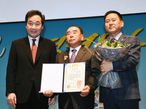 이낙연 국무총리가 6일 서울 공군회관에서 열린 ‘2017년 병역명문가 시상식’에서 가족 15명이 모두 합해 991개월(82년 7개월) 동안 현역으로 병역을 이행해 대통령 표창을 받은 이기옥(가운데)씨 가족과 기념촬영을 하고 있다. 이호정 전문기자 hojeong@seoul.co.kr