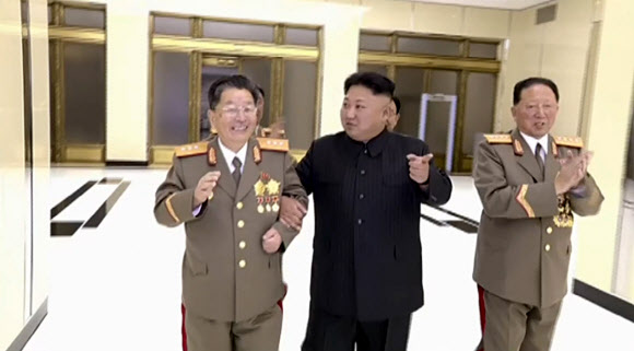 북한 김정은 노동당 위원장이 6차 핵실험에 참여한 핵 과학자·기술자를 위한 축하연회에 참석했다고 조선중앙TV가 보도했다. 사진은 리홍섭 핵무기연구소 소장과 팔짱을 끼고 연회장으로 들어서는 김정은 위원장의 모습. 김 위원장의 오른쪽은 홍승무 당 군수공업부 부부장.  연합뉴스