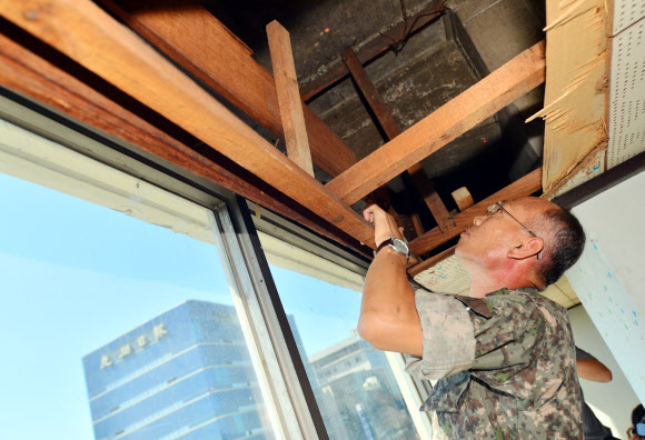 국방부 5·18특별조사위원회가 13일 오후 광주 동구 전일빌딩에서 국과수 감식결과 1980년 5·18 당시 헬기사격이 이뤄진 것으로 추정된 탄흔을 살펴보고 있다.  연합뉴스 