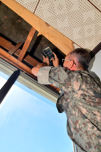 국방부 5·18특별조사위원회가 13일 오후 광주 동구 전일빌딩에서 국과수 감식결과 1980년 5·18 당시 헬기사격이 이뤄진 것으로 추정된 탄흔을 사진 찍고 있다.  연합뉴스