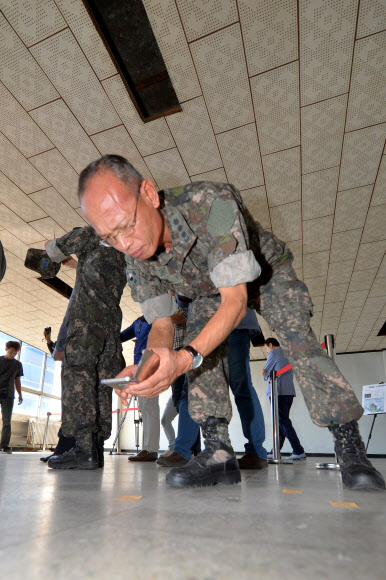 국방부 5·18특별조사위원회가 13일 오후 광주 동구 전일빌딩에서 국과수 감식결과 1980년 5·18 당시 헬기사격이 이뤄진 것으로 추정된 탄흔을 살펴보고 있다. 연합뉴스