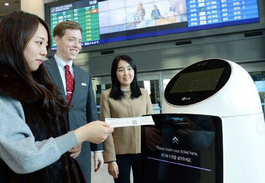 LG CNS 직원들이 14일 인천국제공항에서 LG전자가 개발한 서비스 로봇의 기능을 시험해 보고 있다. LG CNS 제공