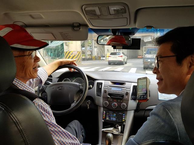 정원오(오른쪽) 서울 성동구청장이 14일 구청에서 시청 방면으로 향하는 택시 안에서 택시기사 이복연씨와 대화하고 있다. 동승했던 기자가 뒷좌석에서 휴대전화로 찍은 사진이다.