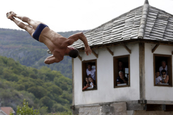 남자 다이빙 선수가 16일(현지시간) 보스니아 헤르체고비나 사라예보 모스타르에서 열린 ‘The Red Bull Cliff Diving World Series 2017’ 중 the Old Mostar Bridge에서 다이빙을 하고 있다. AP 연합뉴스