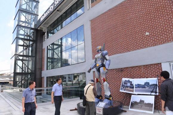 종묘를 바라보는 세운상가 정면 3층 정문 앞에 상가의 기술 장인들과 청년 작가들이 함께 만든 동작 조형물인 ‘세봇’을 시민들이 구경하고 있다. 세봇은 세운과 로봇의 합성어다. <br>이호정 전문기자 hojeong@seoul.co.kr