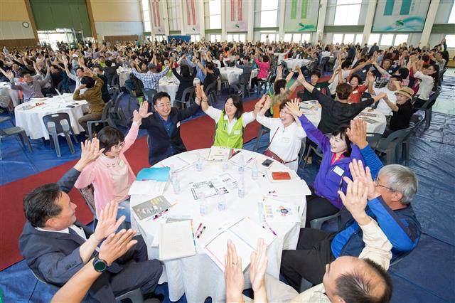 지난 16일 은평다목적체육관에서 열린 참여예산 주민총회에 참석한 구민들이 둘러앉아 서로 손뼉을 치며 화합을 다지고 있다.