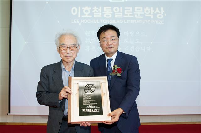 제1회 이호철 통일로 문학상 시상식에서 첫 수상자로 선정된 김석범(왼쪽) 작가와 김 구청장이 상패를 들고 포즈를 취하고 있다.