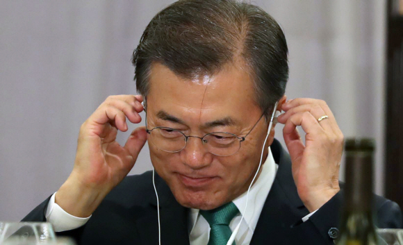 문재인 대통령이 20일 오전 (현지시간) 미국 인터콘티넨탈 뉴욕 바클레이 호텔에서 열린 금융?경제인과의 대화에서 통역기를 귀에 걸며 미소를 짓고 있다. 2017.09.21 뉴욕=안주영 기자 jya@seoul.co.kr