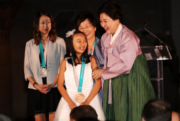 대통령 부인 김정숙 여사가 20일 오후(현지시간) 미국 뉴욕 메트로폴리탄 박물관 새클러윙 에서 열린 ‘평화올림픽을 위한 메트로폴리탄 평창의 밤’ 행사에서 어린이에게 평창올림픽 메달을 목에 걸어준 뒤 격려하고 있다. 연합뉴스