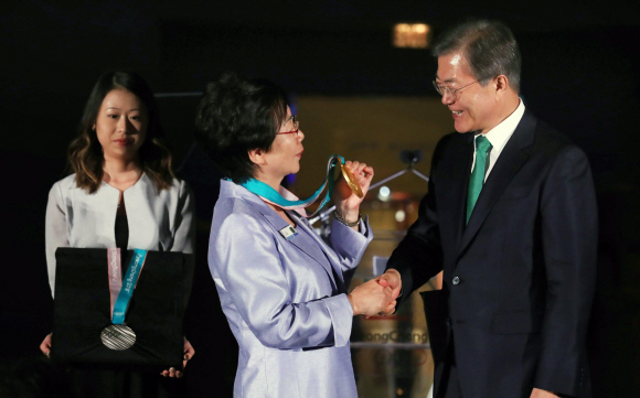 문재인 대통령이 20일 오후(현지시간) 미국 뉴욕 메트로폴리탄 박물관 새클러윙 에서 열린 ’평화올림픽을 위한 메트로폴리탄 평창의 밤’ 행사에서 김귀진 전 스피드 스케이팅 국가대표 선수(가운데)에게 이날 공개된 평창올림픽 금메달을 목에 걸어주며 악수하고 있다. 2017.09.21 뉴욕=안주영 기자 jya@seoul.co.kr