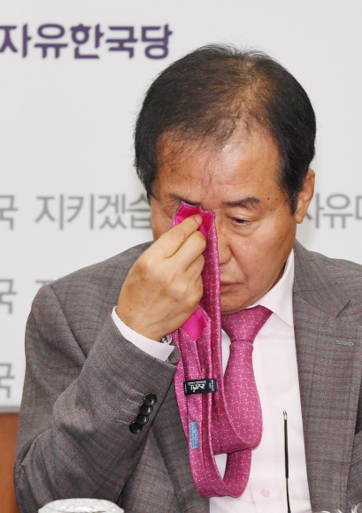 자유한국당 홍준표 대표가 22일 오전 서울 여의도 당사에서 열린 최고위원회의에서 넥타이로 눈을 닦고 있다. 도준석 기자 pado@seoul.co.kr