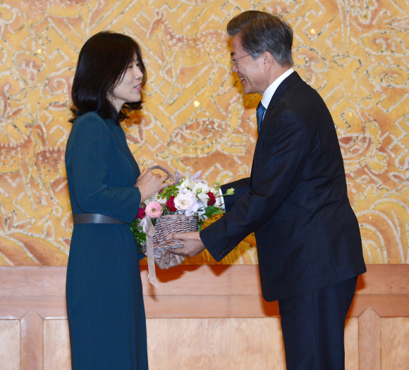문재인 대통령이 25일 청와대 접견실에서 열린 김명수 신임 대법원장 임명장 수여식에시 김 대법원장의 부인 이혜주 여사에게 꽃을 선물하고 있다. 2017. 09. 25 안주영 기자 jya@seoul.co.kr