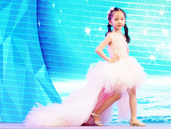 25일(현지시간) 중국 남서쪽 충칭에서 열린 ‘National kids model contest’ 결선에서 참가자들이 무대 위에서 런웨이를 하고 있다. 신화 연합뉴스