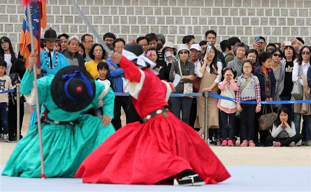 6일 오전 서울 경복궁을 찾은 시민과 관광객들이 궁궐 호위군 사열의식인 ’첩종’재현행사를 관람하고 있다. 어전사열 및 비상대기에 사용되는 큰 종인 ’첩종’은 문부백관 및 중앙군인 오위의 병사들이 모두 집합해 점검을 받던 사열의식을 칭하기도 한다.  뉴스1