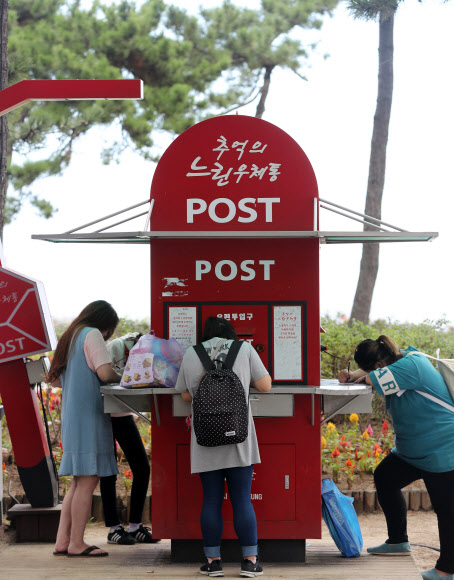 8일 강원 강릉시 경포해변을 찾은 관광객들이 느린 우체통에 추석 연휴의 추억을 남기고 있다.  이 우체통은 관광객이 남긴 편지와 엽서 등을 매년 4월과 12월 발송한다.  연합뉴스