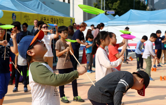 8일 오후 서울광장 주변에서 열린 서울거리예술축제에서 어린이들이 접시 돌리기 체험을 하고 있다. 연합뉴스