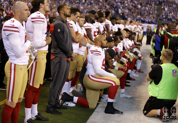 미프로풋볼(NFL) 선수들이 경기가 시작되기 전 국가가 연주되는 동안 ‘무릎 꿇기’로 국민 의례를 거부하고 있는 모습. AP 연합뉴스