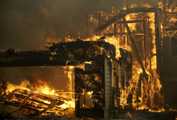 9일(현지시간) 미국 캘리포니아주 북부 나파 등 8개 카운티에 대형 산불이 발생한 가운데 소노마 카운티 산타로사에 있는 집이 불타고 있다. AP 연합뉴스