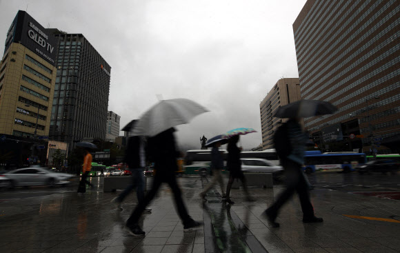 전국 대부분 지역에 비가 내리다 낮에 그칠 것으로 예보된 11일 오전 우산을 쓴 시민들이 서울 광화문 사거리를 지나고 있다.  연합뉴스