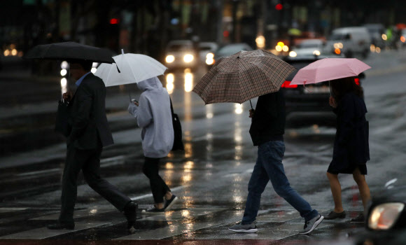 전국 대부분 지역에 비가 내리다 낮에 그칠 것으로 예보된 11일 오전 우산을 쓴 시민들이 서울 광화문 사거리를 지나고 있다.  연합뉴스