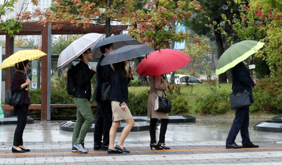 전국 대부분 지역에 비가 내리는 11일 오전 세종시 정부세종청사에서 직원들이 출근하고 있다. 기상청은 이날 비가 낮에 대부분 그친 뒤 기온이 떨어질 것으로 예보했다.  연합뉴스