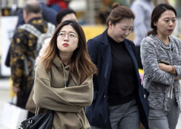 기온이 큰 폭으로 떨어진 12일 오후 서울 광화문광장에서 시민들이 팔짱을 낀 채 횡단보도를 건너고 있다. 연합뉴스