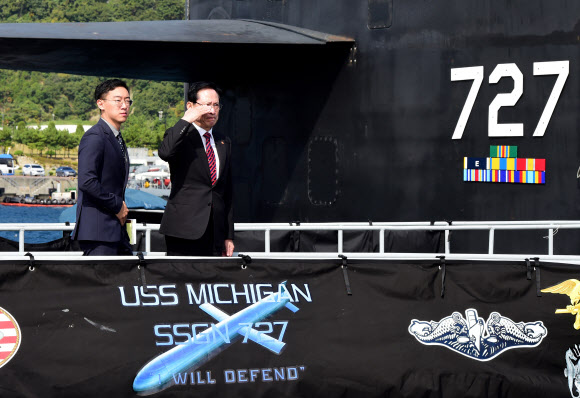 송영무(오른쪽) 국방부 장관이 14일 부산 해군작전사령부를 찾아 미국의 핵추진 잠수함 미시간함에 승선해 장병을 향해 거수경례를 하고 있다. 국방부 제공