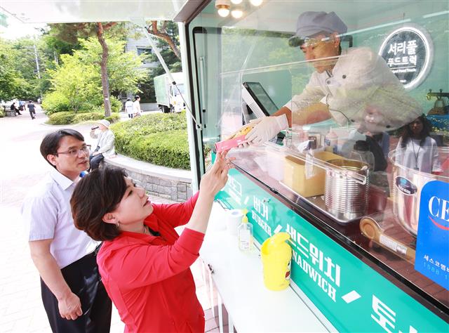 조은희 서초구청장이 강남역 인근 푸드트럭에서 간식을 사고 있다. 유명 셰프 강의 등을 지원해 일대 불법 노점상을 푸드트럭사업자로 전환시키면서 강남역 9~10번 출구 인근은 푸드트럭 명소로 부상했다.<br>서초구 제공