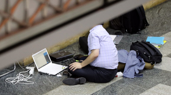 2017년 국정감사가 중반으로 들어선 19일 오전 국회 한 상임위원회 국감장 인근 차가운 바닥에 피감기관 관계자가 앉아 자료를 준비하고 있다. 매년 국회 국정감사 기간에는 피감기관이 몰려 상임위원회 인근 복도에 마련된 간이 사무공간(70여석)의 자리가 부족해 피감기관 관계자들이 아침부터 자리 잡기에 나서고 있다. 연합뉴스