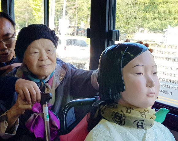 19일 오전 경기도 수원시 권선구 92번 시내버스에서 일본군 위안부 피해자 안점순(89) 할머니가 버스에 탄 ’평화의 소녀상’을 어루만지고 있다.  연합뉴스