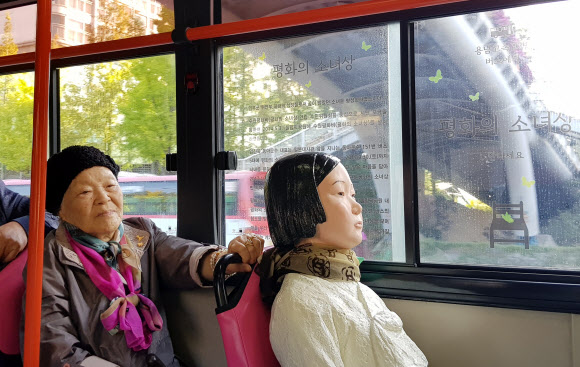 19일 오전 경기도 수원시 권선구 92번 시내버스에서 일본군 위안부 피해자 안점순(89) 할머니가 버스에 탄 ’평화의 소녀상’과 함께하고 있다.  연합뉴스