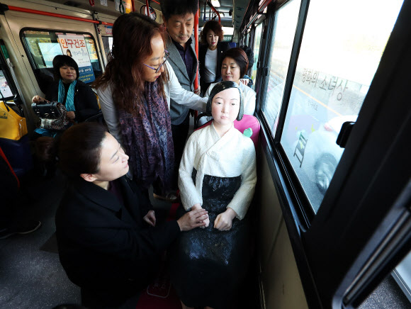 19일 오전 경기도 수원시 권선구 곡반정동 차고지에서 수원평화나비 등 관계자들이 일본군 위안부 피해자를 기리는 ’평화의 소녀상’을 태운 92번 버스에 올라 소녀상을 바라보고 있다. 연합뉴스