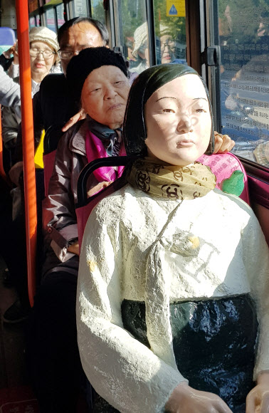 19일 오전 경기도 수원시 권선구 92번 시내버스에서 일본군 위안부 피해자 안점순(89) 할머니가 버스에 탄 ’평화의 소녀상’과 함께 하고 있다. 연합뉴스