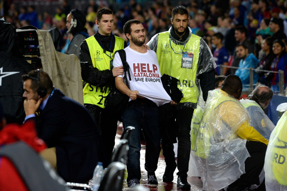 18일(현지시간) 스페인 바르셀로나의 캄프누 경기장에서 열린 유럽축구연맹(UEFA) 챔피언스리그 경기 도중 ‘카탈루냐를 돕고 유럽을 구하자’는 내용이 새겨진 티셔츠를 입은 한 관중이 보안 요원들에 의해 끌려 나오고 있다. 바르셀로나 AFP 연합뉴스