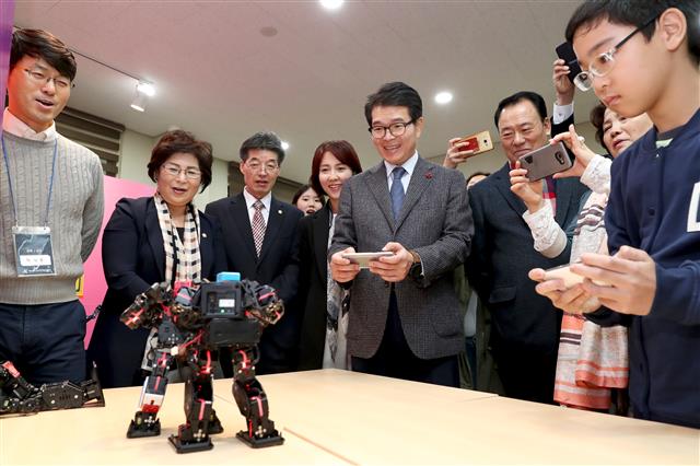 25일 개관한 ‘4차산업혁명체험센터’를 찾은 정원오(왼쪽 다섯 번째) 성동구청장이 로봇체험장에서 한 초등학생과 함께 로봇 복싱을 하고 있다.<br>성동구 제공