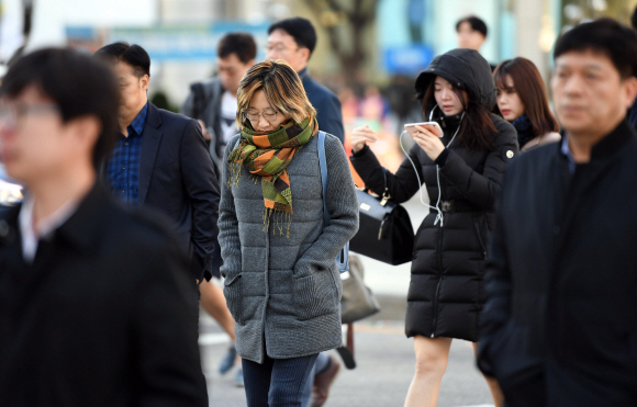 찬 공기와 강풍의 영향으로 기온이 크게 떨어진 30일 서울 종로구 광화문 네거리에서 출근하는 시민들이 걸음을 재촉하고 있다. 기상청은 이날 서울의 아침 최저기온이 영상 3도로 내려가고 강원 산간과 일부 내륙은 수은주가 영하로 떨어져 얼음이 어는 등 올 가을 들어 가장 추운 날씨를 보일 것이라고 예보했다. 2017. 10. 30. 박윤슬 기자 seul@seoul.co.kr