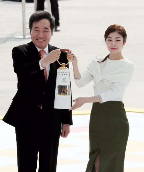 이낙연 국무총리(오른쪽)와 김연아 평창 동계올림픽 홍보대사가 1일 오전 인천공항 제2터미널에서 성화램프를 들어보이고 있다. 박윤슬 기자 seul@seoul.co.kr