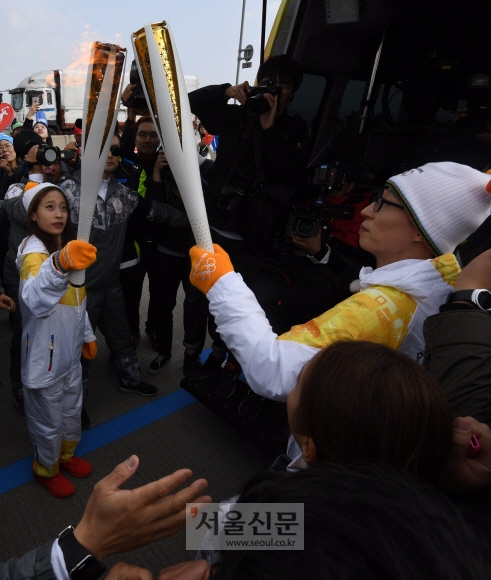 2018 평창동계올림픽 국내 두 번째 성화봉송 주자인 ‘국민MC’ 유재석이 1일 인천시 중구 인천대교에서 1번 주자인 스케이트 선수 유영으로부터 성화를 이어받고 있다.<br>박윤슬 기자 seul@seoul.co.kr