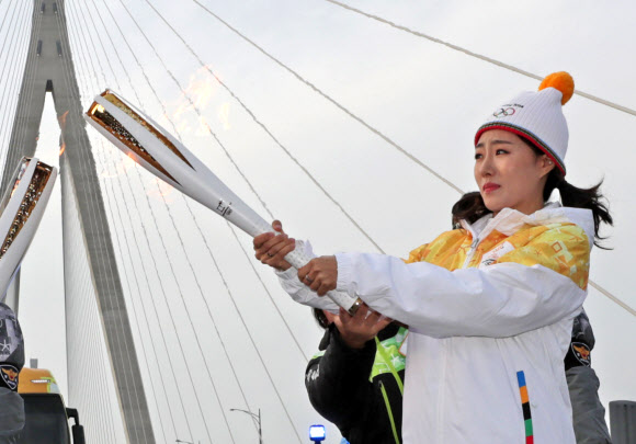  개막이 99일 남은 2018 평창동계올림픽에서 스피드스케이팅 여자 500m 3연패를 노리며 한국선수단의 종합 4위 도전에 앞장서는 이상화가 1일 인천대교에서 성화 봉송의 60번째 주자로 나서 불꽃을 이어받으며 설핏 놀라고 있다. 연합뉴스 