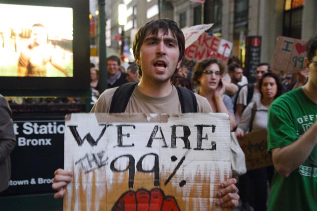 2011년 미국 뉴욕 맨해튼에서 열린 월가 점령 시위에서 한 청년이 ‘우리는 99%다’고 쓴 피켓을 들고 있다. ‘똑똑함의 숭배’ 저자는 ‘광적으로 이익을 도모하는 (소득 상위) 1%와 똑같이 부유한 정부 고위층을 나머지 99% 대중이 어떻게 믿을 수 있겠느냐’고 되묻는다. 갈라파고스 제공