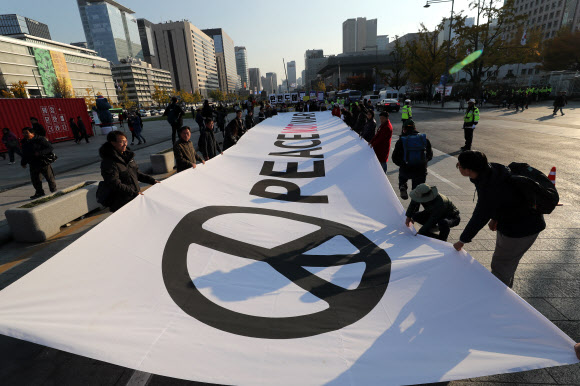 5일 오후 서울 광화문 세종로공원에서 열린 ’트럼프 방한 즈음 시민평화행동 Peace Sunday’의 집회에서 참가자들이 전쟁반대와 평화협상을 촉구하며 행진하고 있다.  연합뉴스