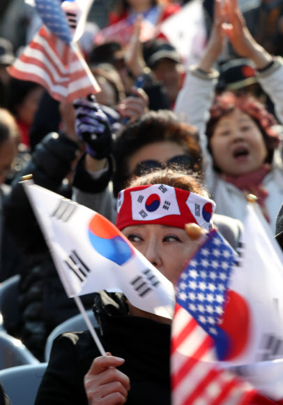 5일 오후 서울역 광장에서 열린 트럼프 미국 대통령의 방한 환영 집회에서 참가자들이 태극기와 성조기를 흔들고 있다.  연합뉴스