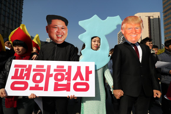 5일 오후 서울 광화문 광장에서 청년정당 우리미래 당원들이 트럼프 미국 대통령 방한을 앞두고 반전 퍼포먼스를 하고 있다.  연합뉴스