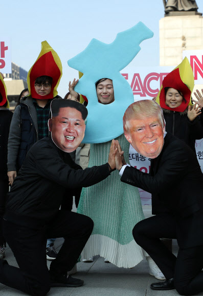 5일 오후 서울 광화문 광장에서 청년정당 우리미래 당원들이 트럼프 미국 대통령 방한을 앞두고 반전 퍼포먼스를 하고 있다.  연합뉴스