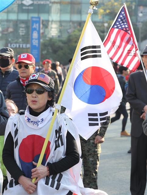 5일 오후 서울 중구 봉래동 서울역광장에서 열린 한미 동맹강화 및 트럼프 대통령 환영대회에서 참가자들이 태극기와 성조기를 흔들고 있다.  뉴스1