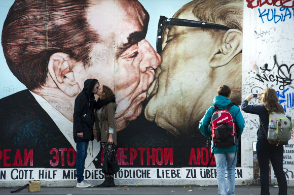 2014년 독일 통일 20주년 기념으로 재연된 베를린 장벽에 브레즈네프와 호네커의 키스 장면이 그려진 앞에서 관광객들이 입맞춤을 하고 있다. 서울신문 포토라이브러리