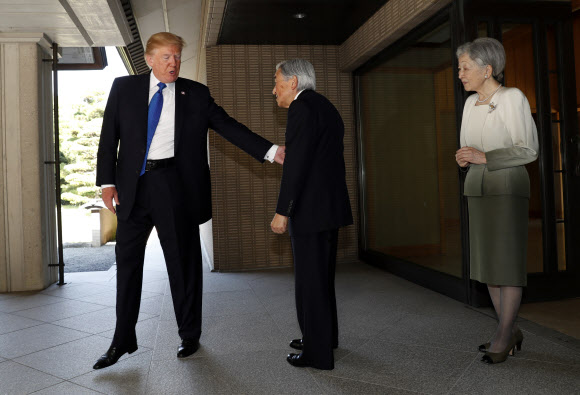 도널드 트럼프 미국 대통령이 6일 일왕 아키히토의 팔을 가볍게 치며 친근감을 표하고 있다. AP연합뉴스